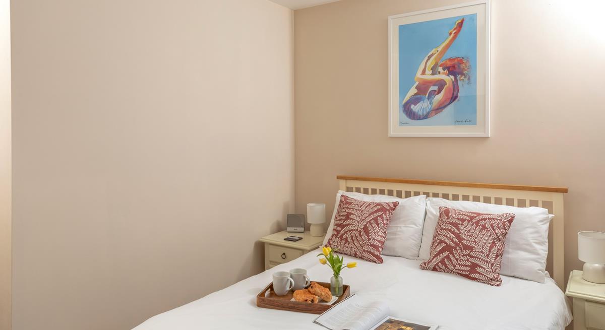 Bright artwork adorns the double bedroom wall.