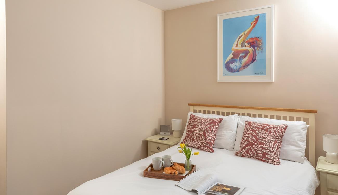 Bright artwork adorns the double bedroom wall.
