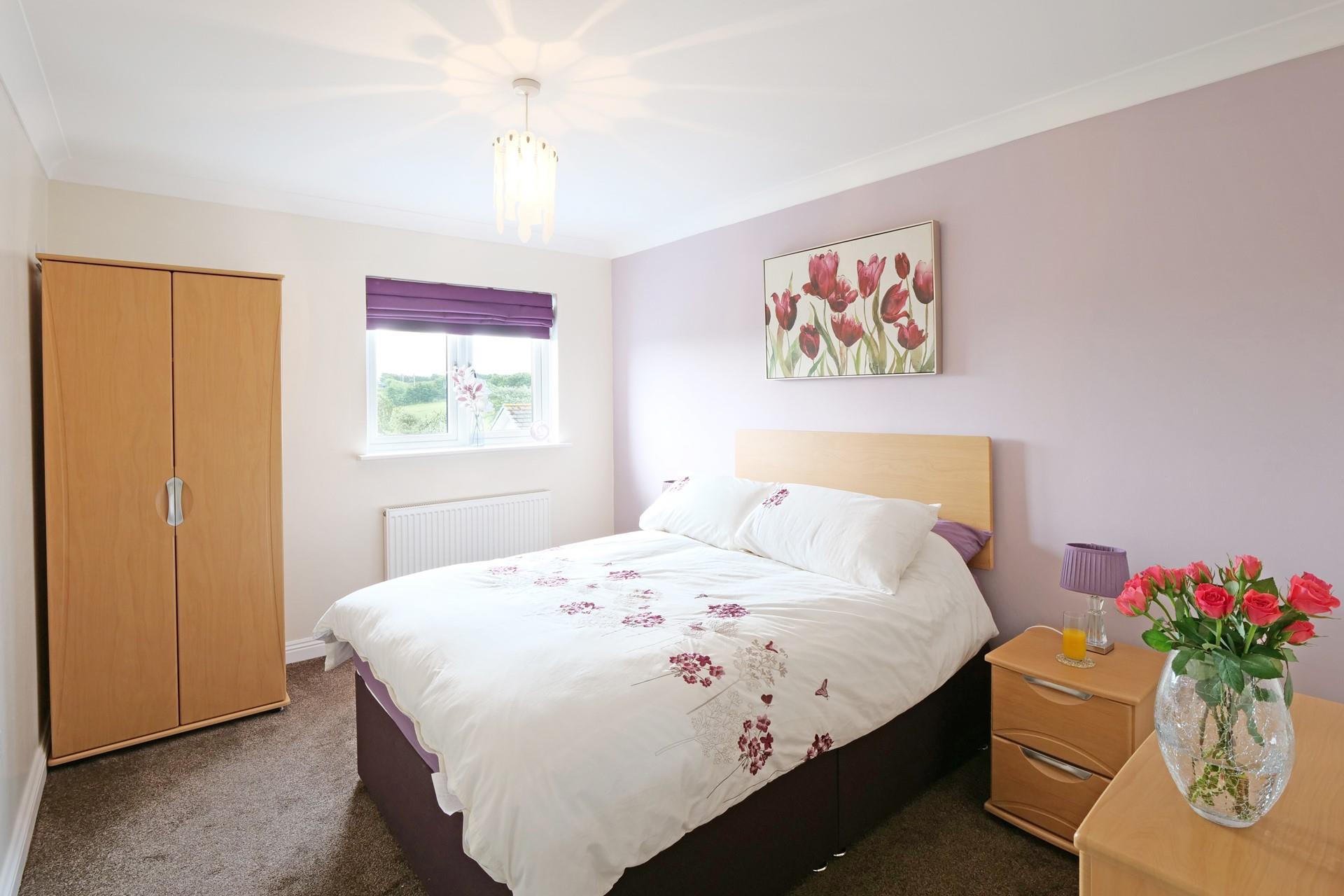 This spacious double bedroom is warm and inviting for a restful night's sleep.