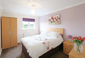 This spacious double bedroom is warm and inviting for a restful night's sleep.