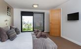 Bedroom 3 has a king size bed with a wall-mounted TV and a sea view across St Ives bay. - Thumbnail Image