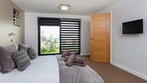 Bedroom 3 has a king size bed with a wall-mounted TV and a sea view across St Ives bay.