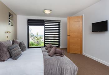 Bedroom 3 has a king size bed with a wall-mounted TV and a sea view across St Ives bay.