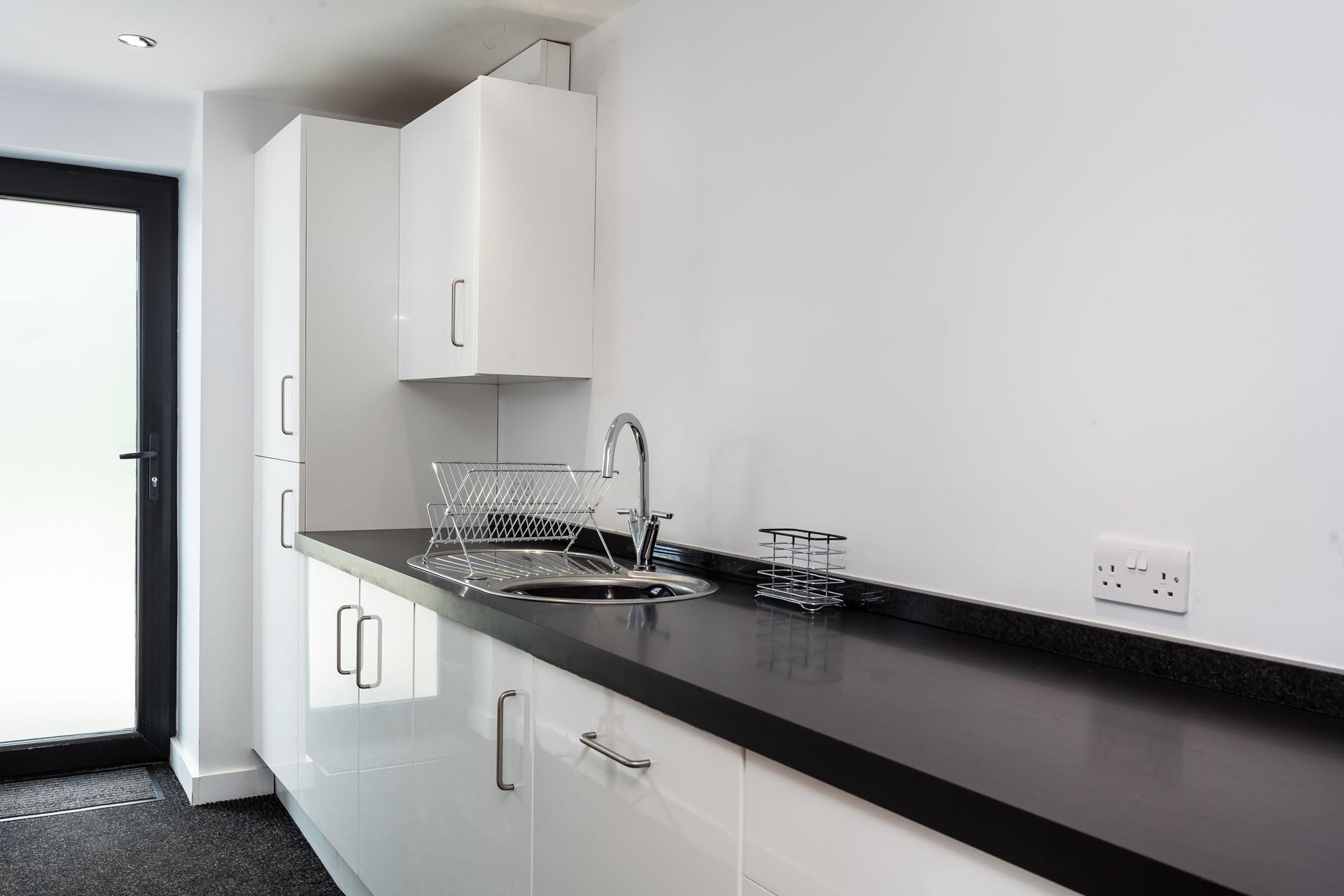 The utility area is sleek and has an ample worktop, a sink with a drainer and several cupboards for extra storage.