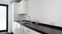 The utility area is sleek and has an ample worktop, a sink with a drainer and several cupboards for extra storage.