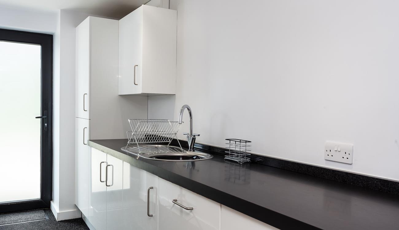 The utility area is sleek and has an ample worktop, a sink with a drainer and several cupboards for extra storage.