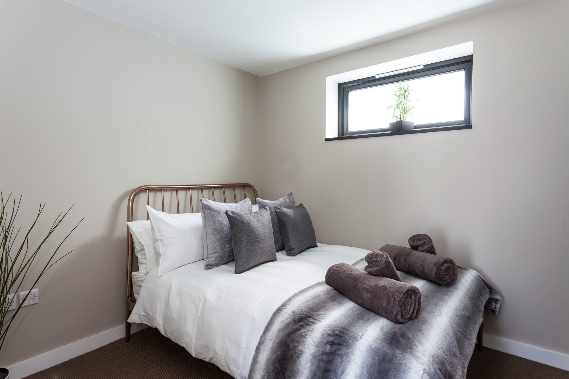 Bedroom 2 has a contemporary grey decor for a calming space to relax.