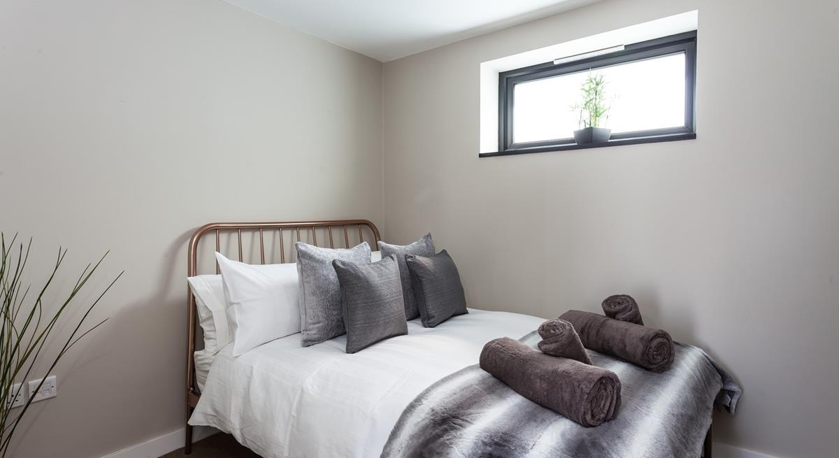 Bedroom 2 has a contemporary grey decor for a calming space to relax.