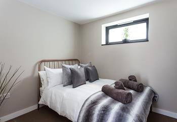 Bedroom 2 has a contemporary grey decor for a calming space to relax.
