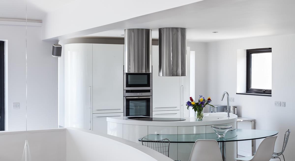 Curved contemporary lines have created a fantastic kitchen area in the living space, which captures pure light and angles.