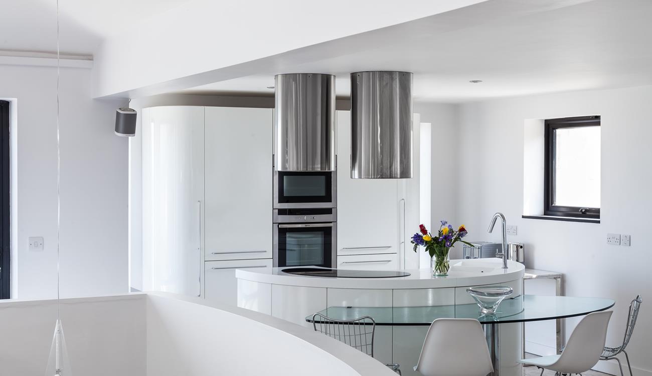 Curved contemporary lines have created a fantastic kitchen area in the living space, which captures pure light and angles.