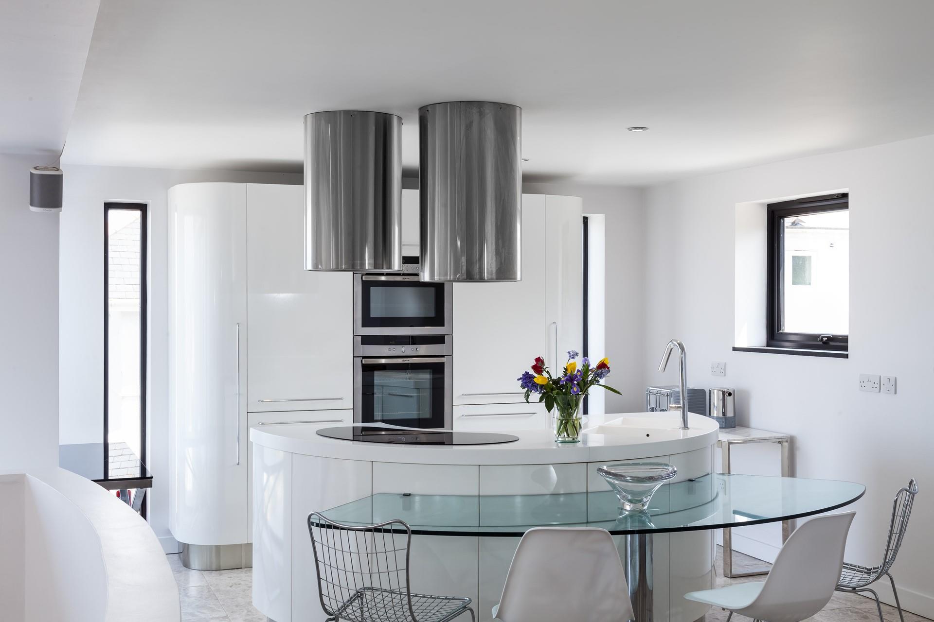 Full-length vertical windows run each side of the main kitchen cupboards, offering lots of natural light.