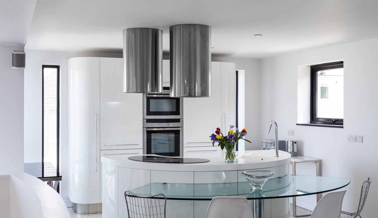 Full-length vertical windows run each side of the main kitchen cupboards, offering lots of natural light.