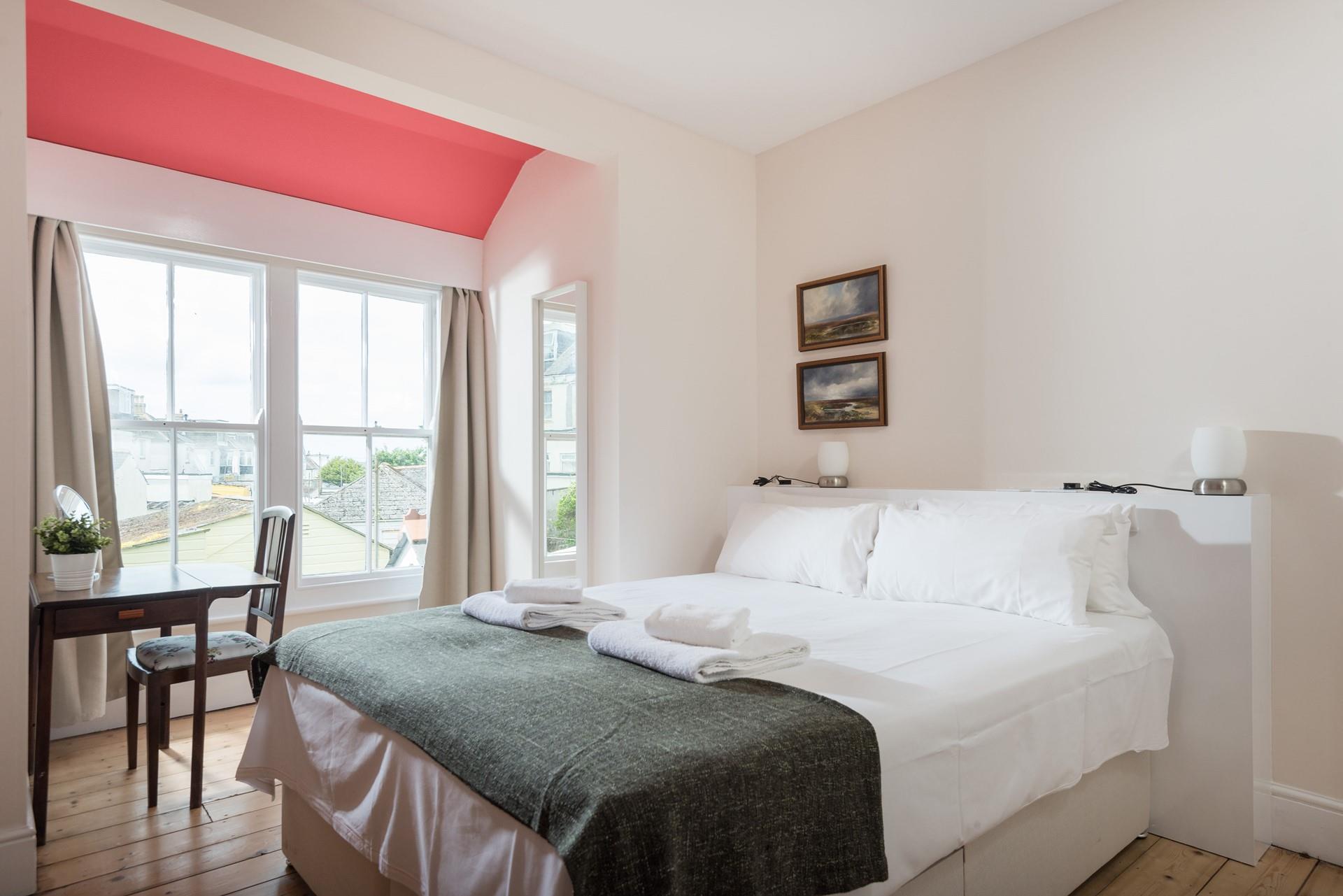 Bedroom 3 at the back of the house, has zip and link beds and a window overlooking the garden.