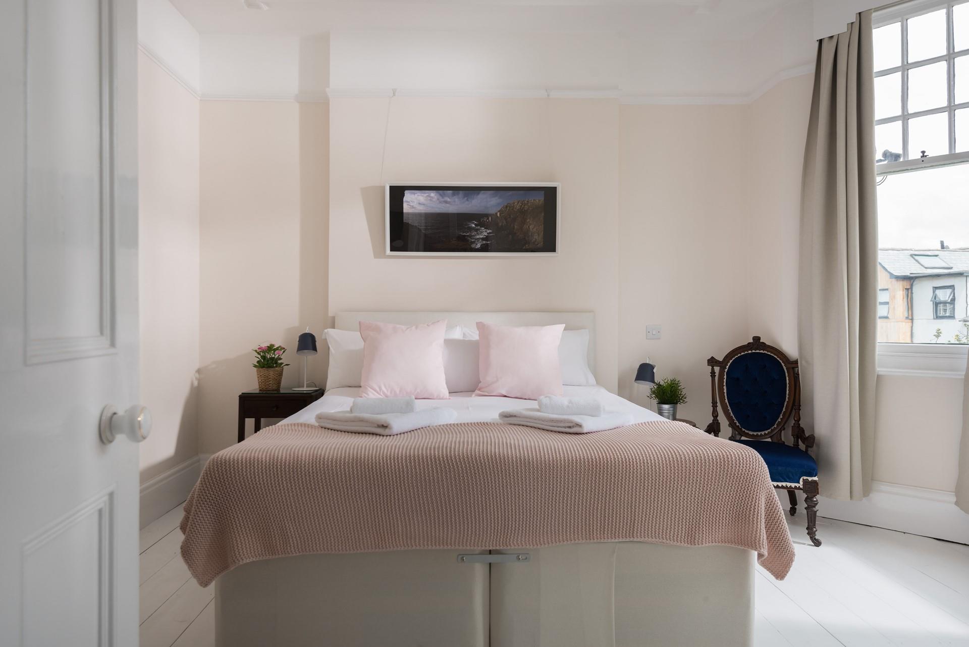 The bedroom is spacious with large windows ensuring the space feels light and airy.