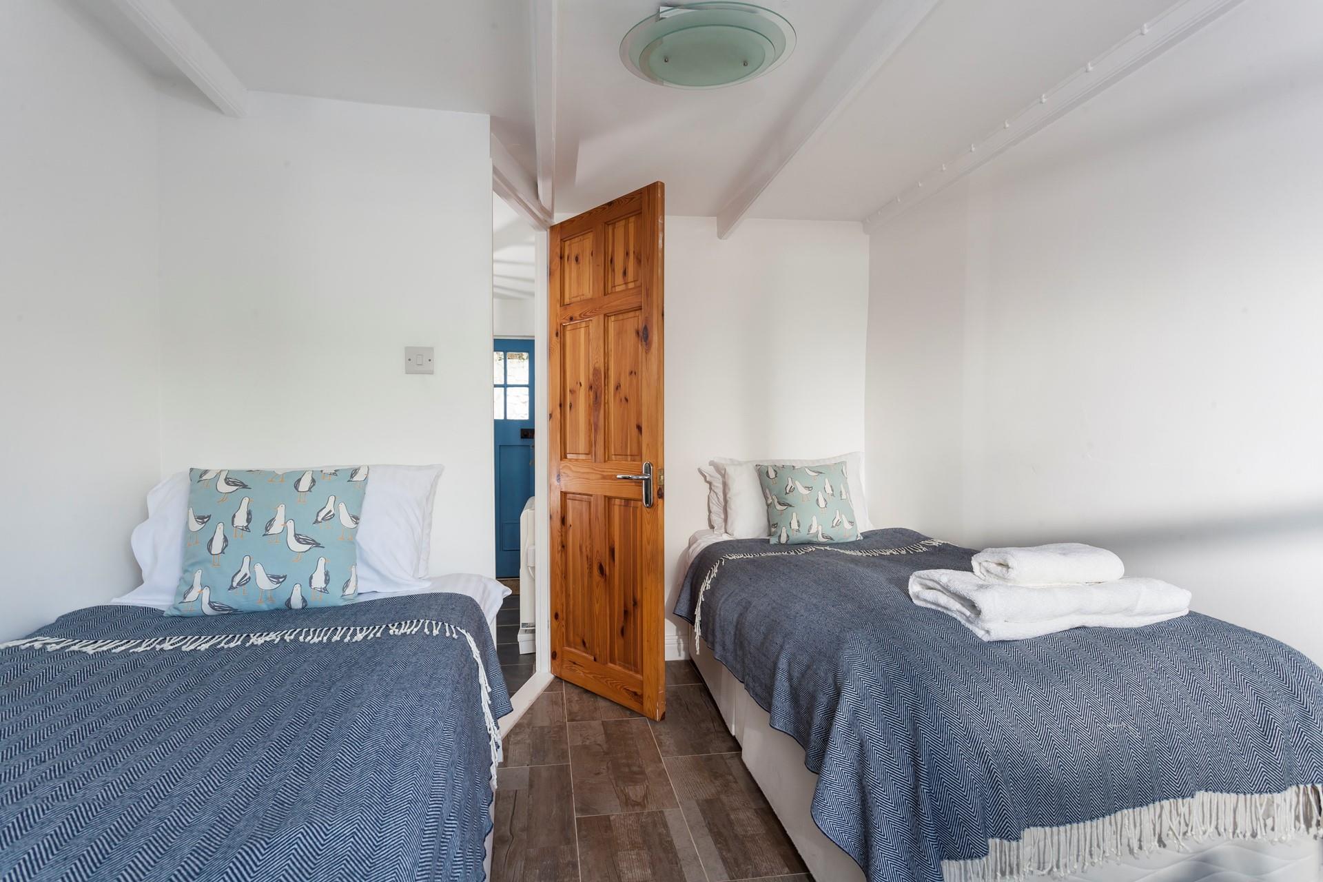 Bedroom 2 has blue blankets and quirky seagull cushions.
