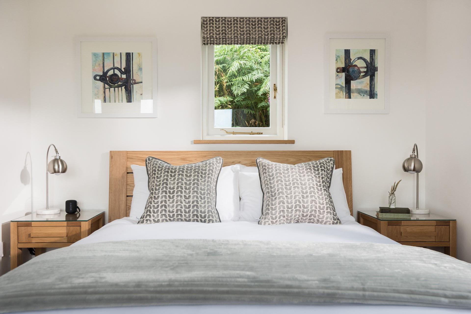 Tastefully decorated, the luxurious bedroom benefits from a king size bed. We love the feature window behind the headrest.