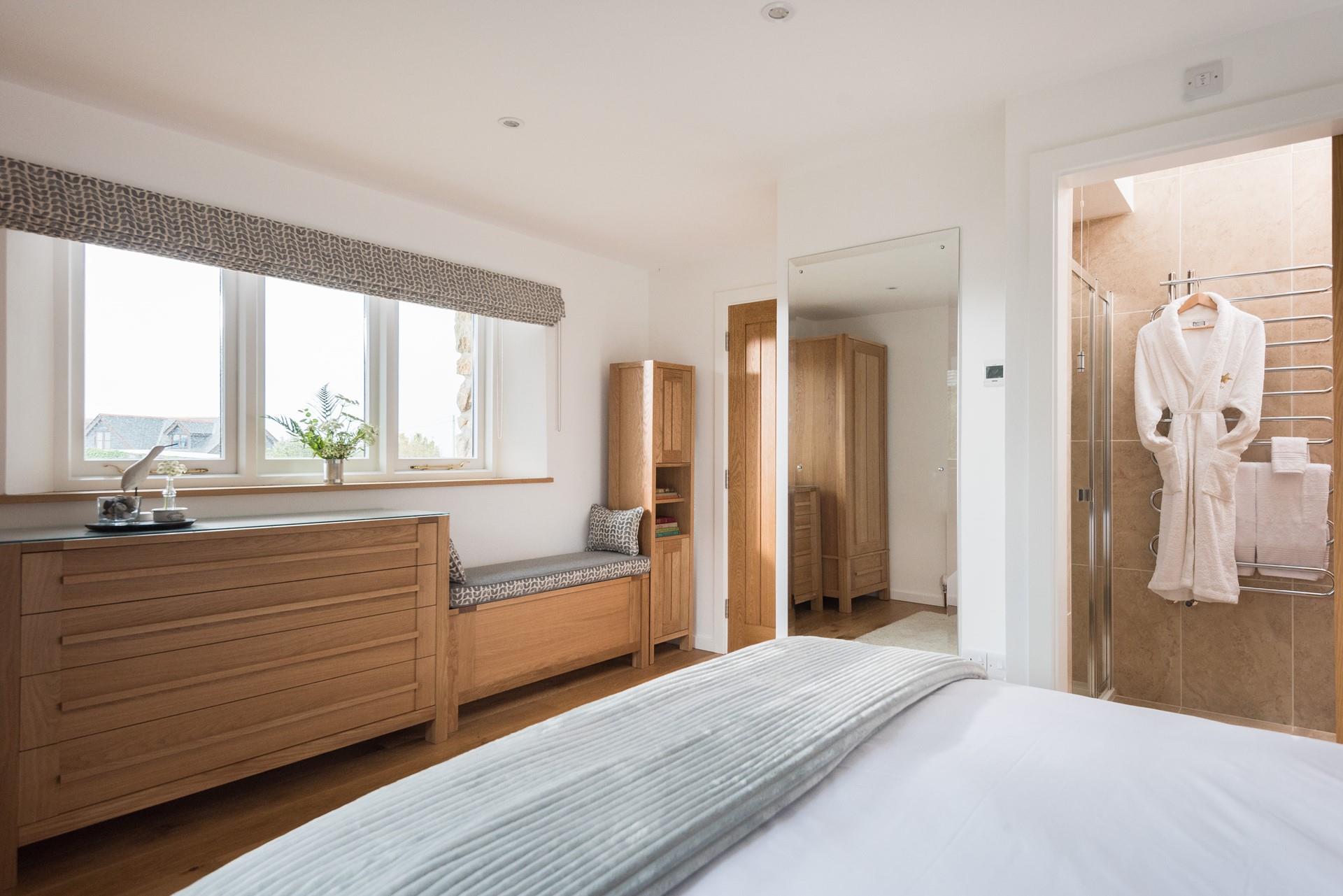 Spacious, light, and airy, the bedroom features bespoke, built-in furniture. 