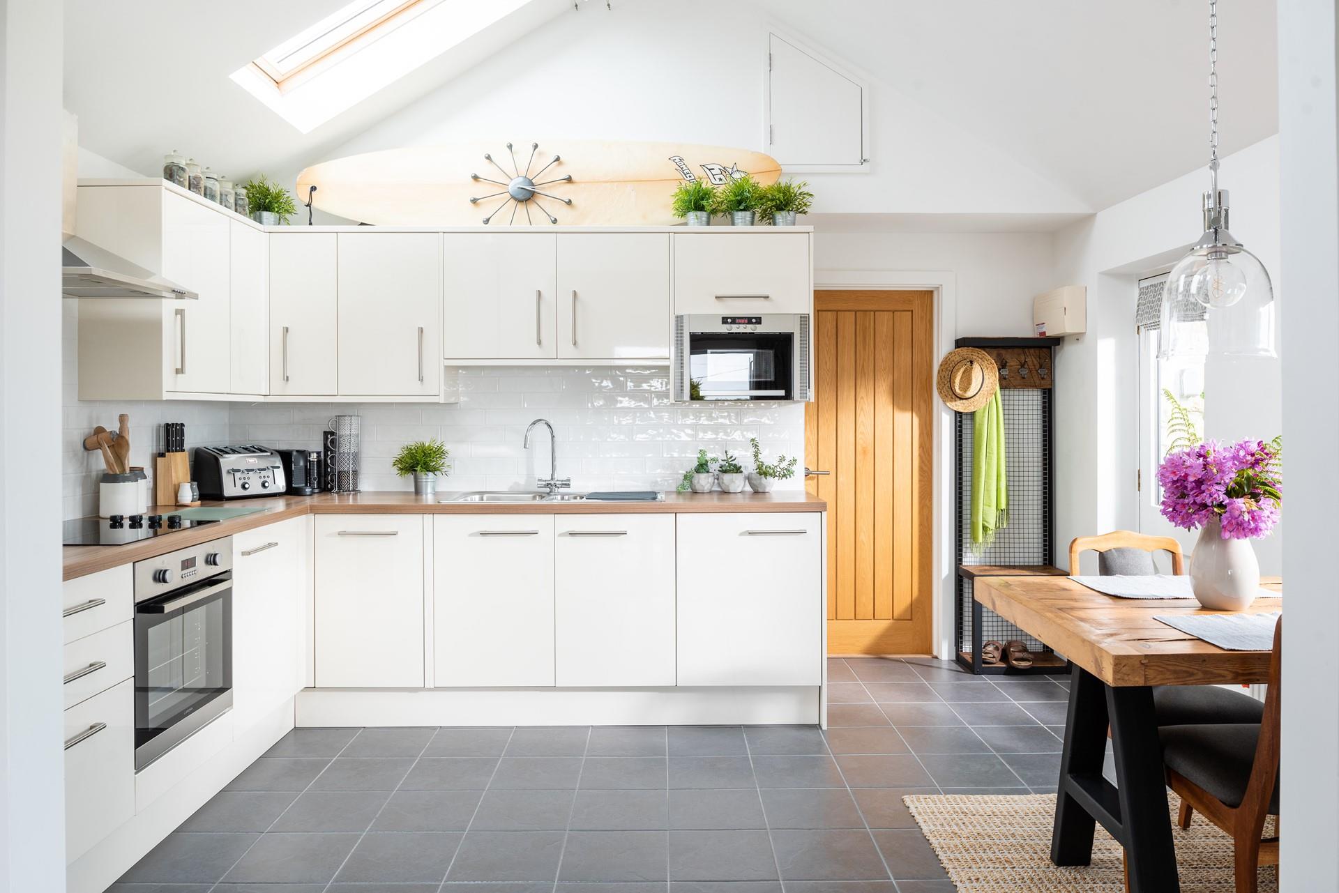 This sleek and stylish kitchen is complimented by the chunky wooden table. 