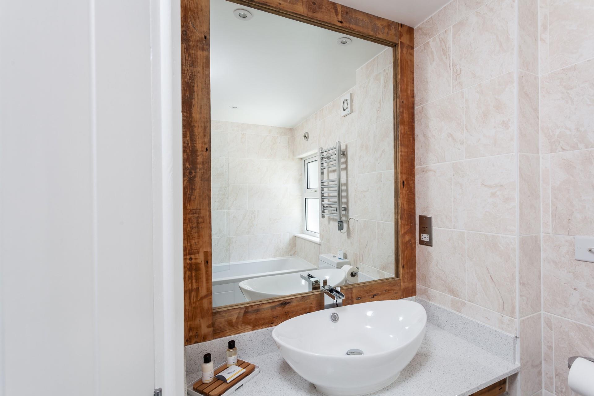 Sleek tiles, a large mirror and basin style sink ensure the en suite feels both lavish and practical; perfect for getting ready for the day ahead.