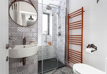 The modern bathroom features mosaic tiles and is the perfect space to get ready in the morning.