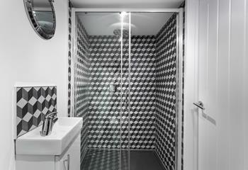 Bedroom 3 has an en suite, finished with mosaic tiles and a rainfall shower.