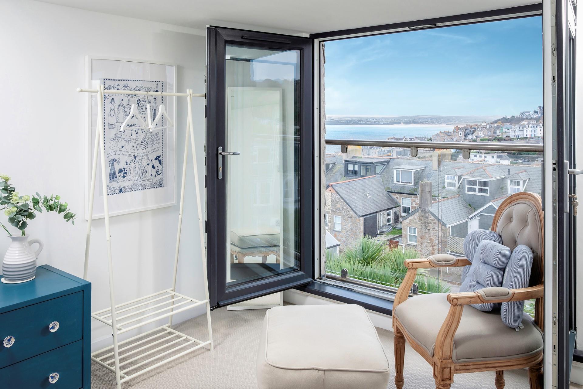 This bedroom also has its very own Juliette balcony with sea views, there's a chair and matching footstool perfect for taking in the views.