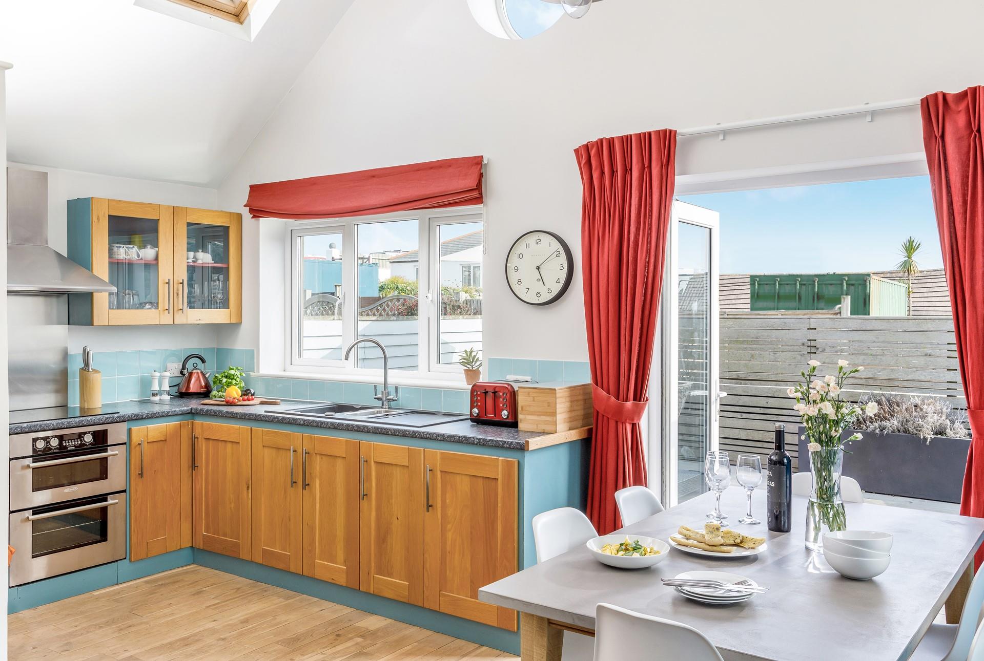 The gorgeous kitchen with its blue hues is well-equipped and benefits from sea views so you can even enjoy the waves whilst cooking!