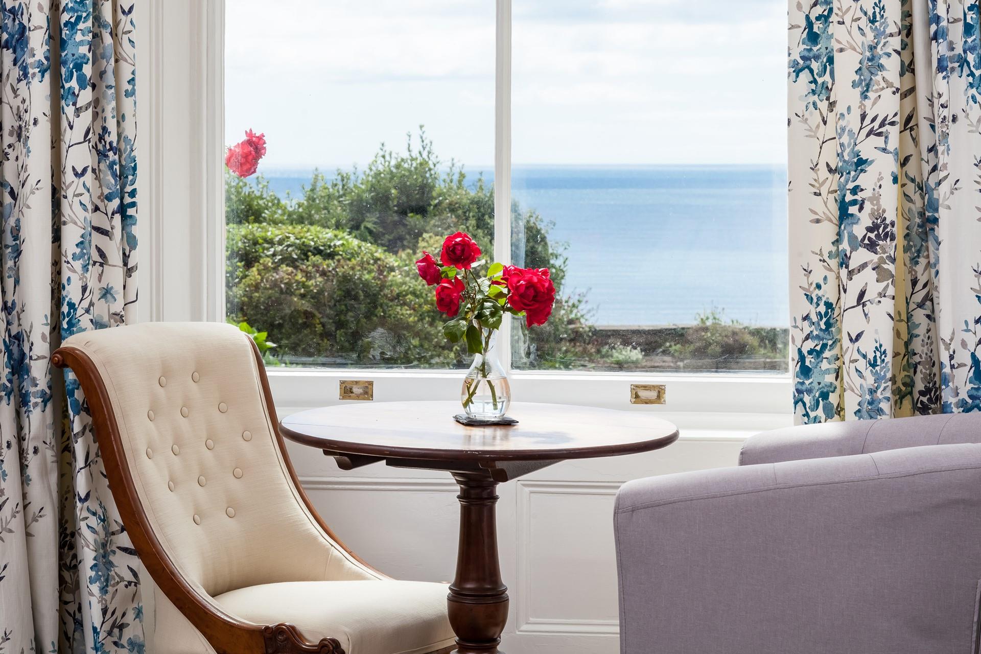 Seating by the window in the sitting room looks across the garden and out to sea. 