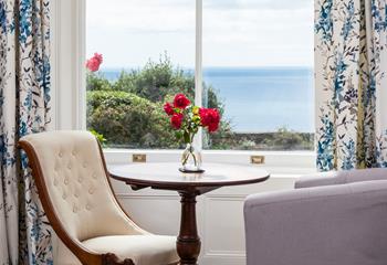 Seating by the window in the sitting room looks across the garden and out to sea. 
