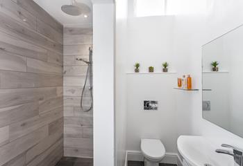 The contemporary wet room has a spacious walk-in rainfall shower.