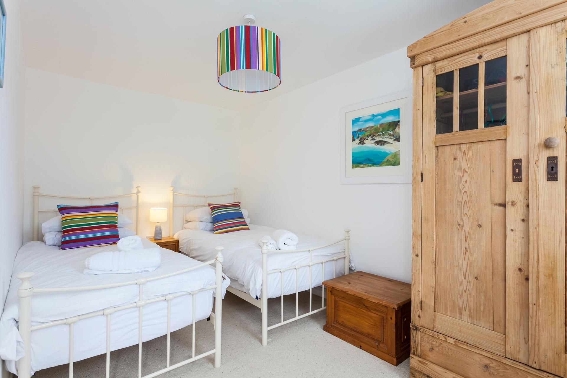 We love the bright and airy twin room in this gorgeous seaside cottage. 