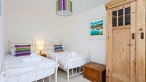 We love the bright and airy twin room in this gorgeous seaside cottage. 