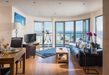 The open plan living area has fantastic floor-to-ceiling windows, making the most of the property's sensational sea views.