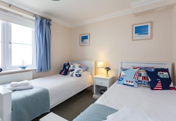 The spacious twin room is in keeping with the apartment's coastal theme. 