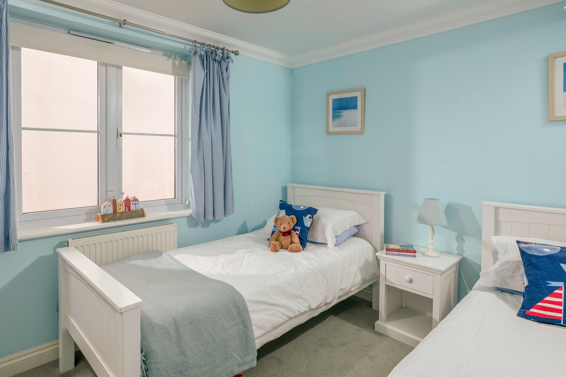 The spacious twin room is in keeping with the apartment's coastal theme. 