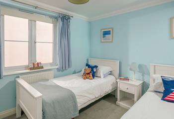 The spacious twin room is in keeping with the apartment's coastal theme. 