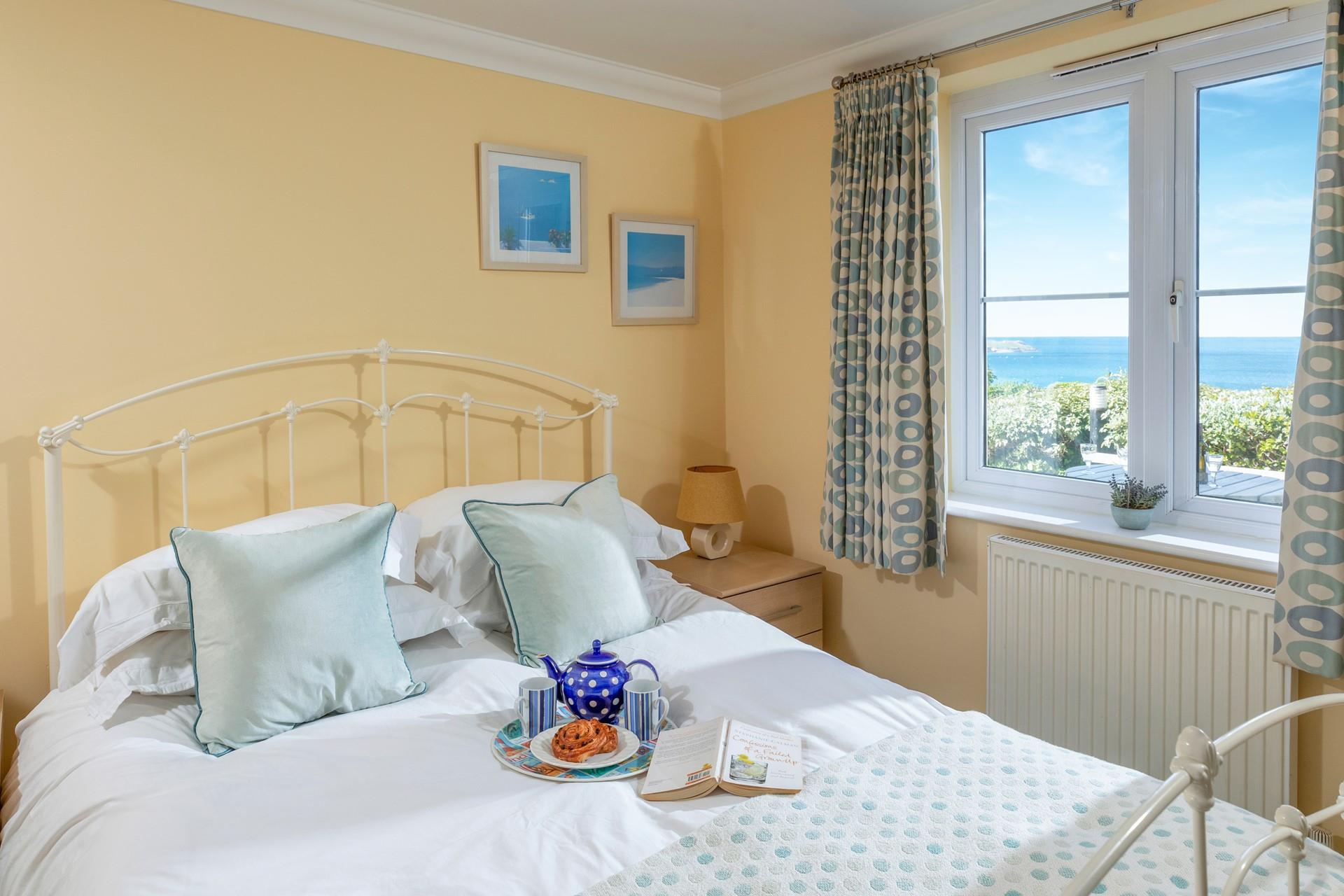 Dual-aspect windows fill the bedroom with ample natural light; throw open the windows to let the fresh coastal air stream in. 