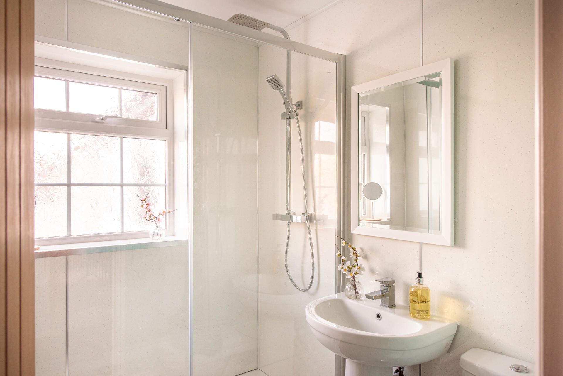 The large rainfall shower adds a touch of luxury to the bathroom, perfect for invigorating morning showers or freshening up before a night out.