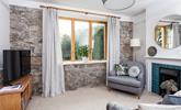 The exposed granite wall adds a traditional feel to the cosy sitting room.  - Thumbnail Image