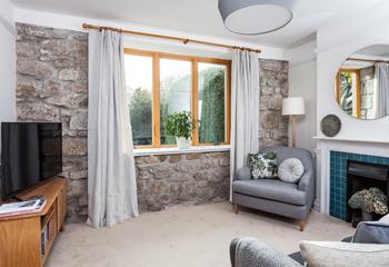 The exposed granite wall adds a traditional feel to the cosy sitting room. 