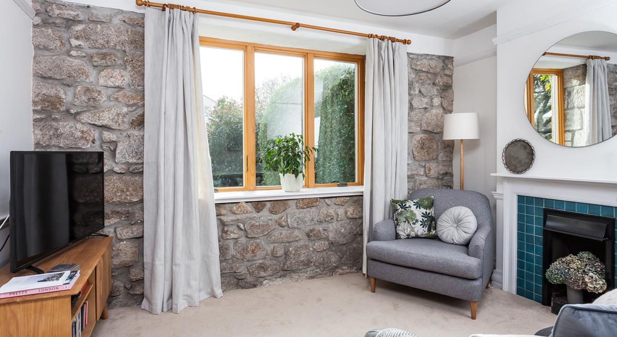 The exposed granite wall adds a traditional feel to the cosy sitting room. 