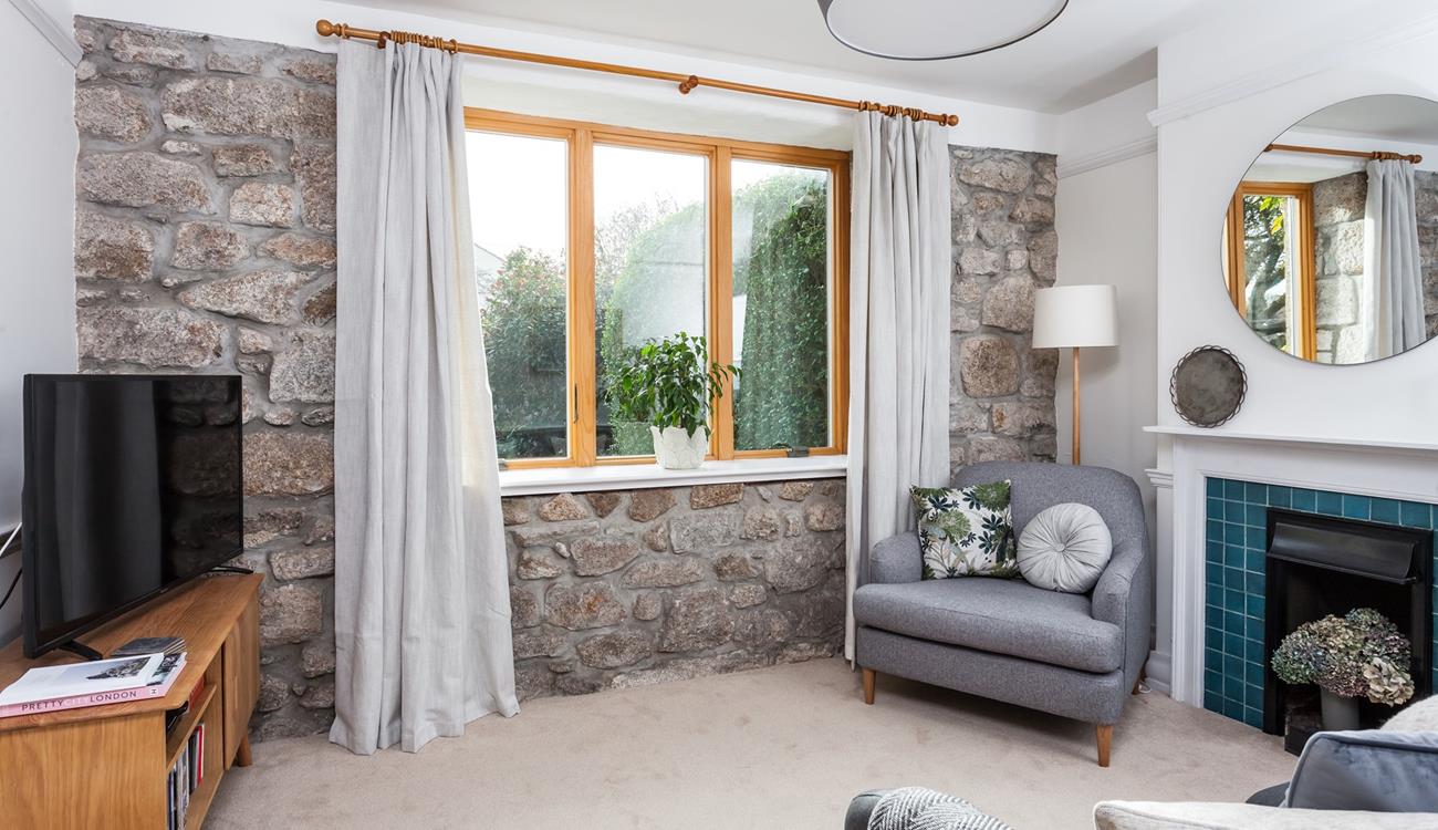 The exposed granite wall adds a traditional feel to the cosy sitting room. 