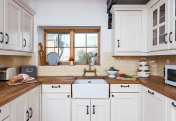 The light and airy kitchen has plenty of storage and all the comforts of home. 