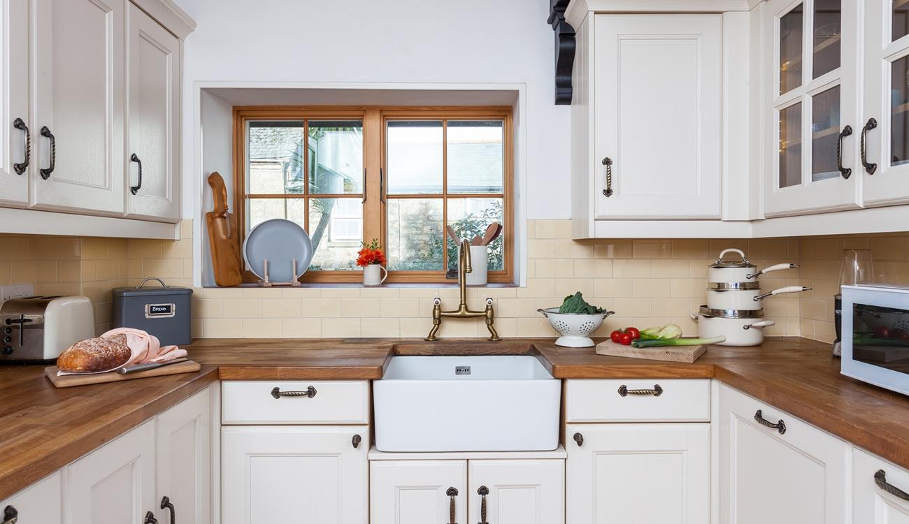 The light and airy kitchen has plenty of storage and all the comforts of home. 