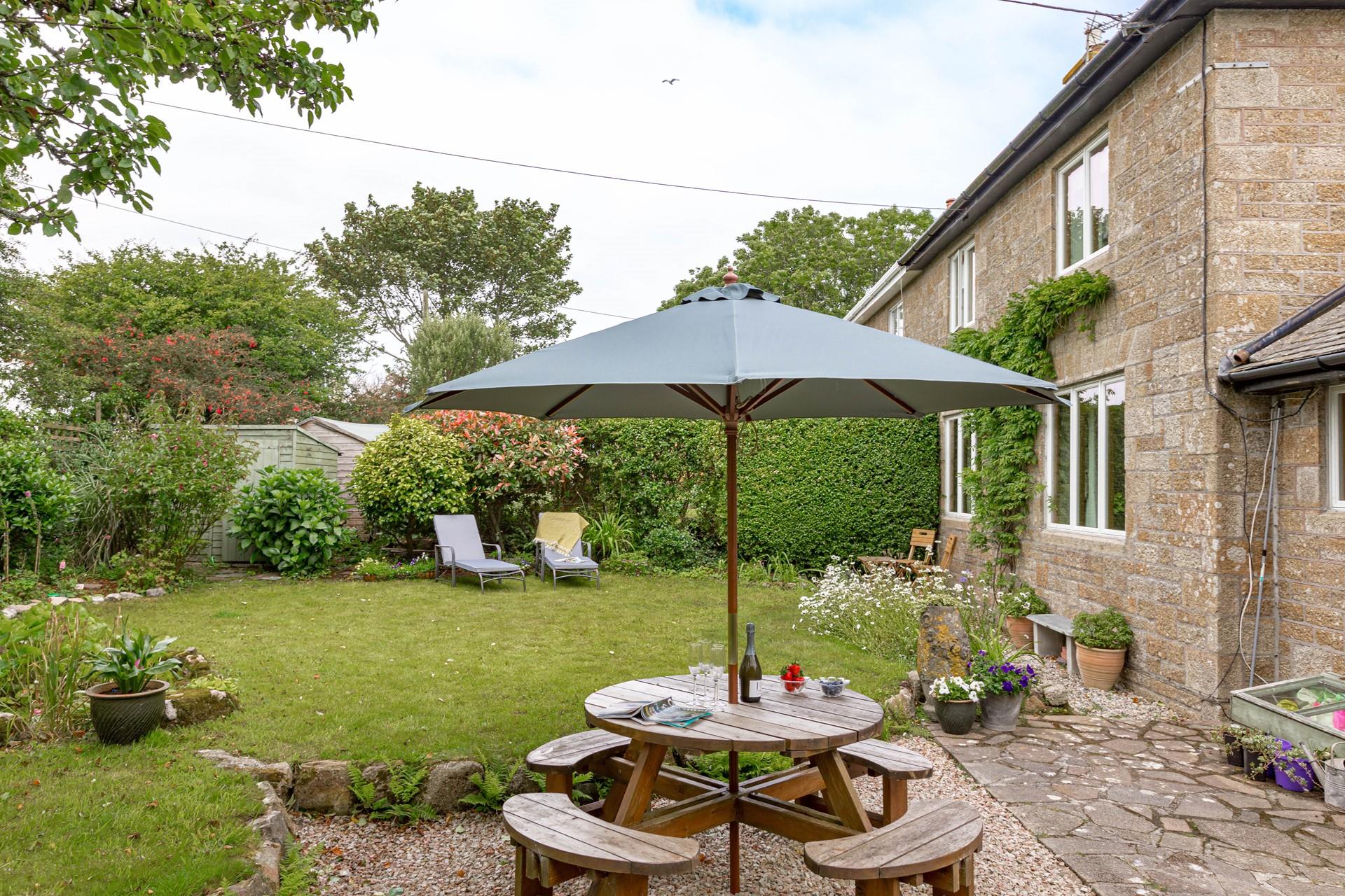 The rear garden at Folnamodry has a large apple tree and plenty of outside space to relax and enjoy a drink.