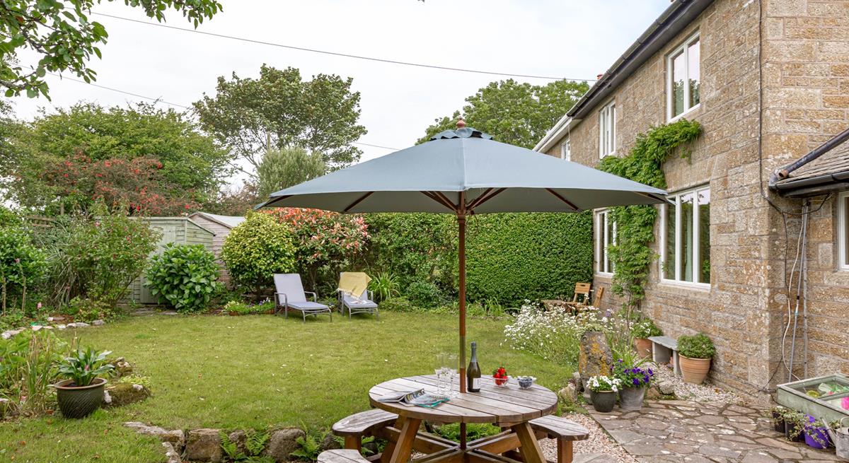The rear garden at Folnamodry has a large apple tree and plenty of outside space to relax and enjoy a drink.