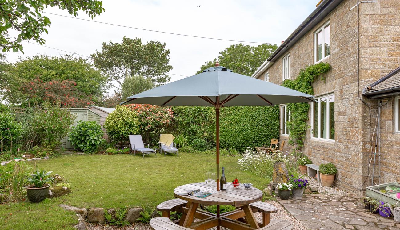 The rear garden at Folnamodry has a large apple tree and plenty of outside space to relax and enjoy a drink.