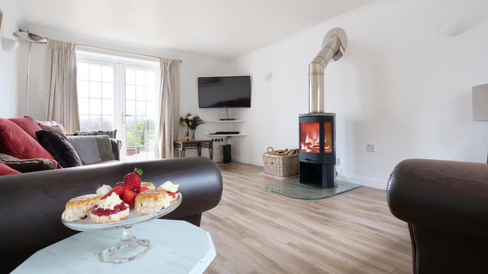 Spacious and airy, the sitting room features a stylish woodburner for those cooler evenings. 