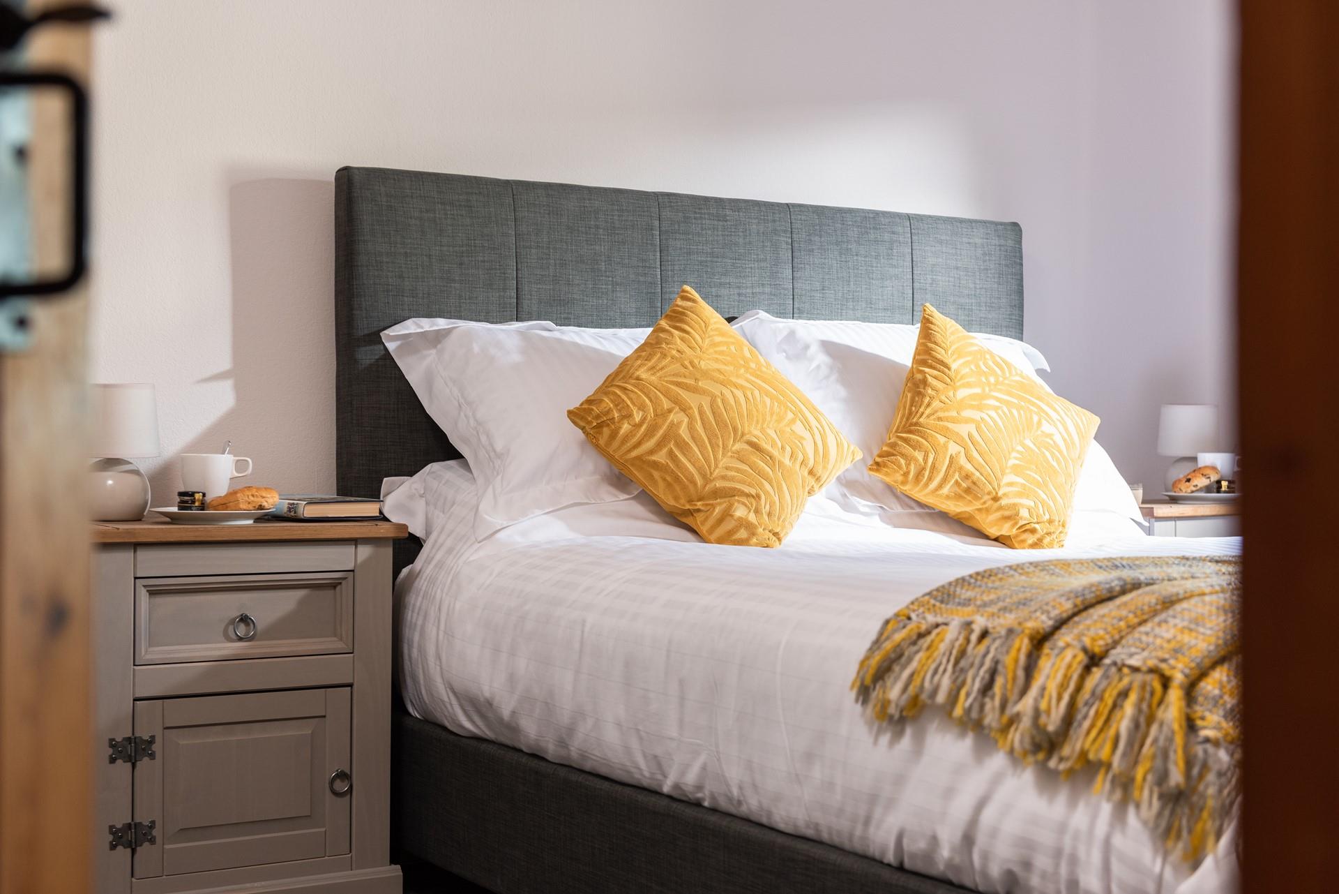 Soft white linen and velvet cushions add a touch of luxury to the master bedroom. 